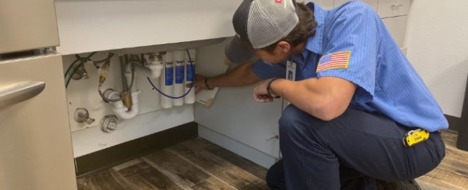 Plumber installing water filtration system